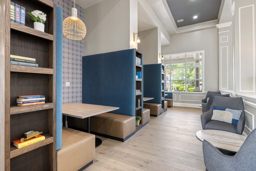 a living room with tables , chairs , shelves and a window at The Preserve at Ballantyne Commons in Charlotte, NC.