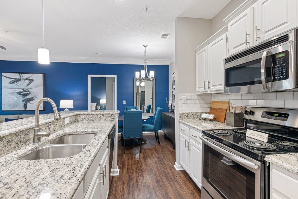a kitchen with stainless steel appliances and granite counter tops at The Preserve at Ballantyne Commons in Charlotte, NC.