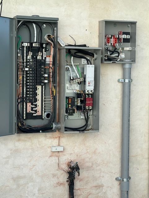 An electrician is working on an electrical outlet with a multimeter.