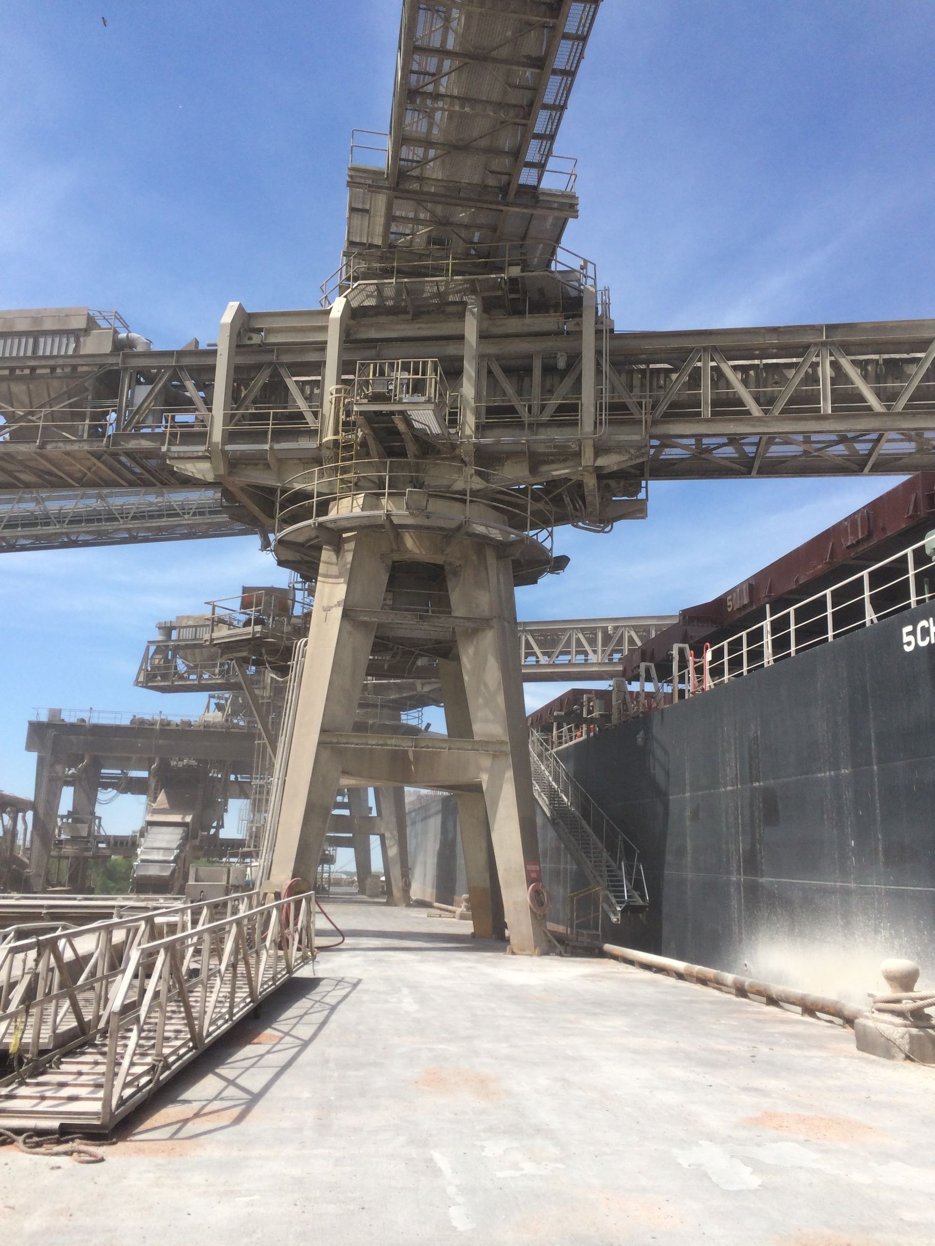 A large crane is sitting next to a large ship