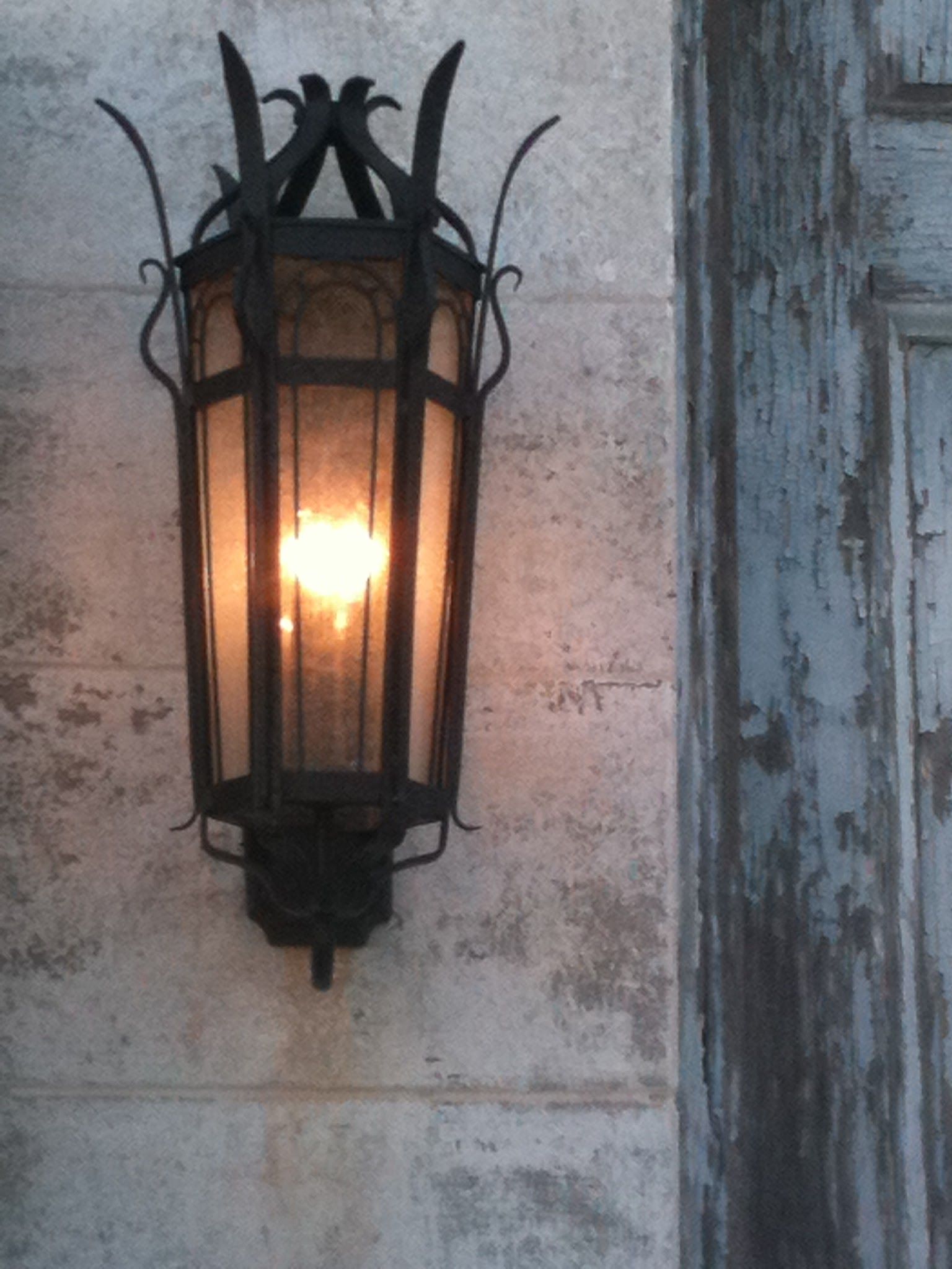 A lantern is hanging on a wall next to a door