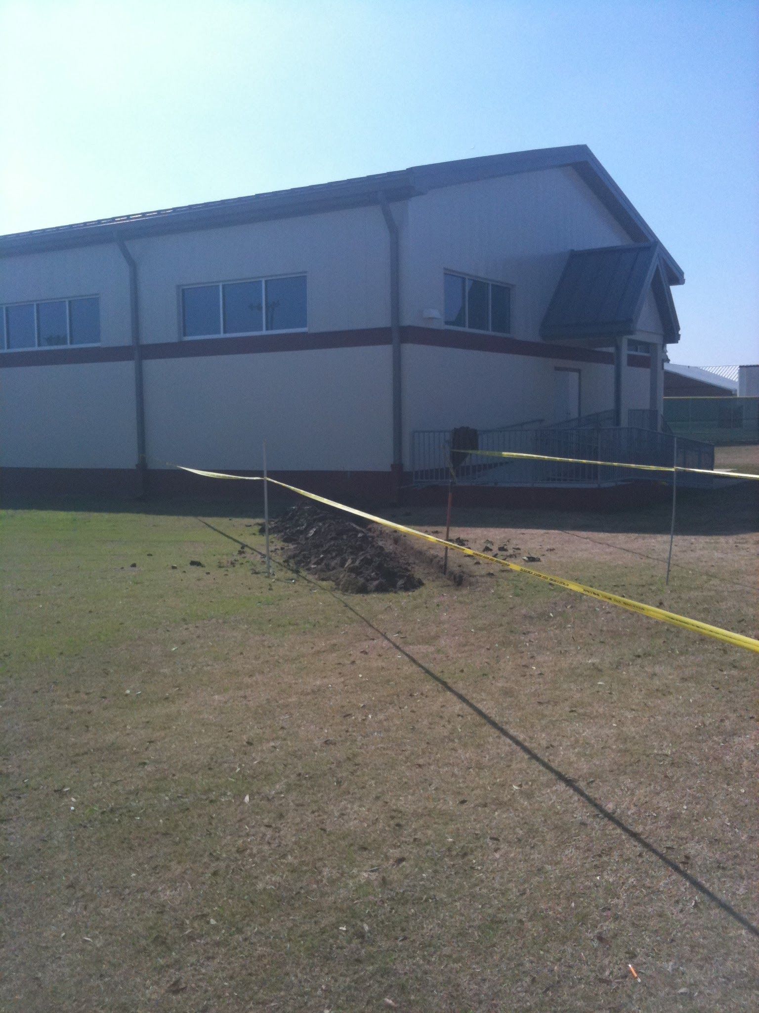 A large white building with a red stripe on the side