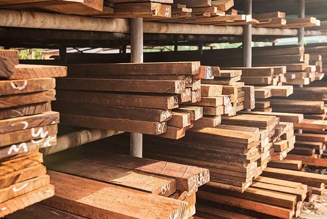 A warehouse filled with lots of wooden boards stacked on top of each other.