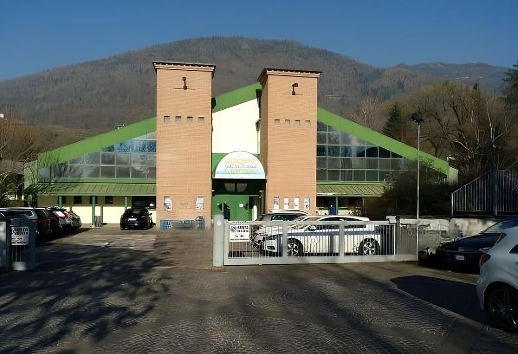 Un edificio con molte auto parcheggiate di fronte