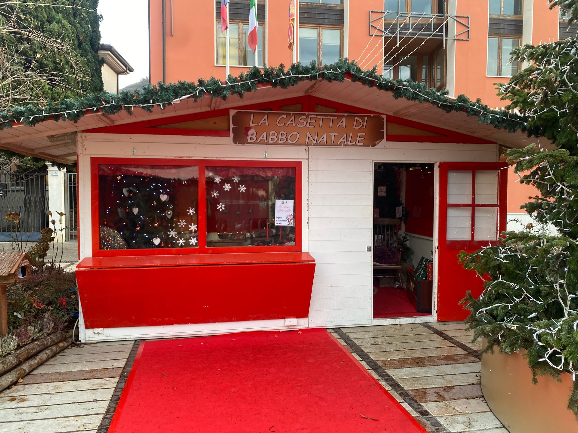 Un edificio rosso e bianco con un tappeto rosso davanti.