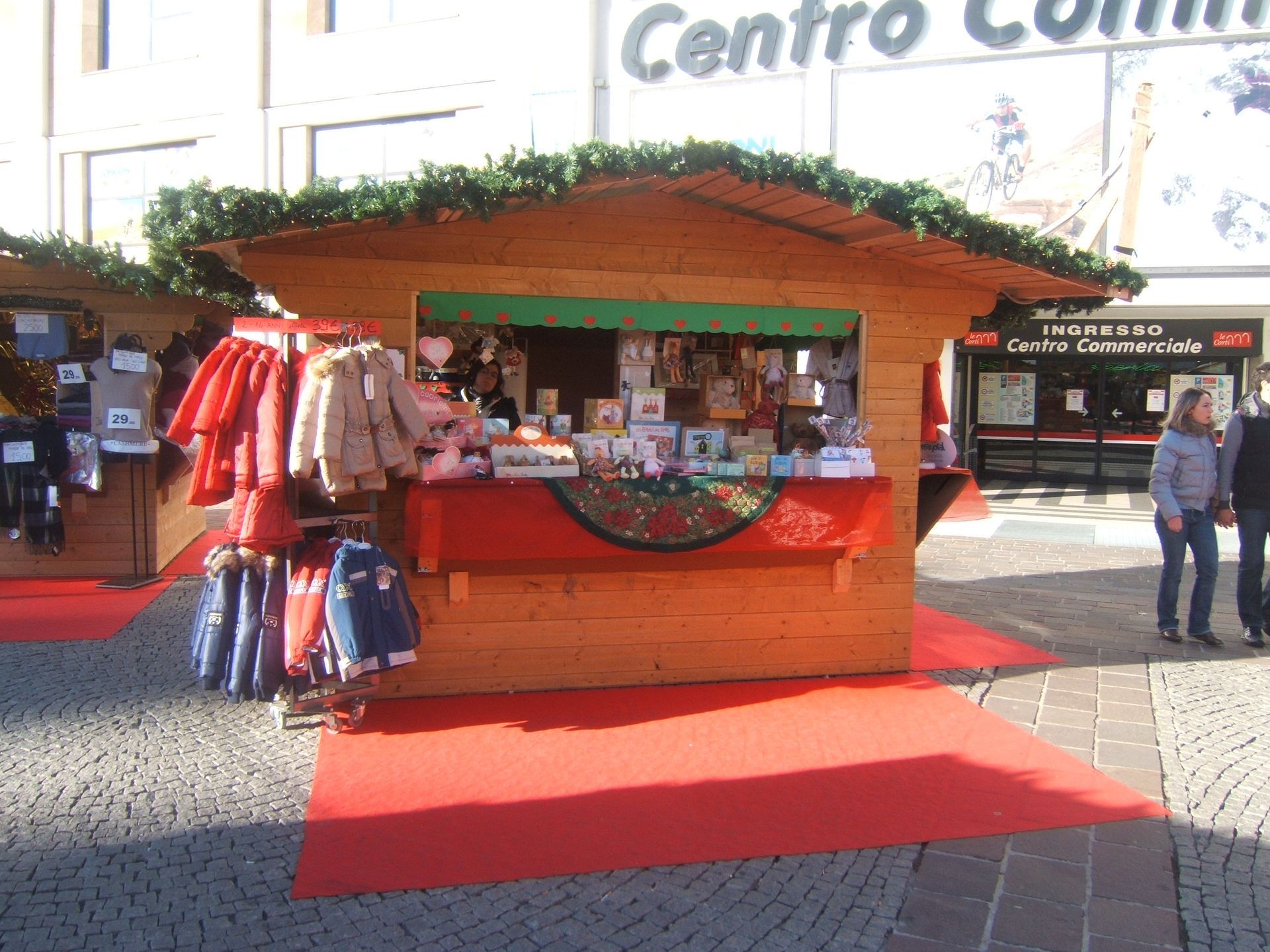 Un chiosco di legno con vestiti esposti di fronte a un edificio che dice centro