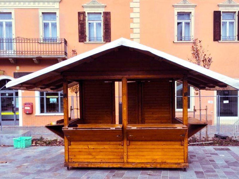 Un piccolo edificio di legno con un tetto bianco di fronte a un edificio