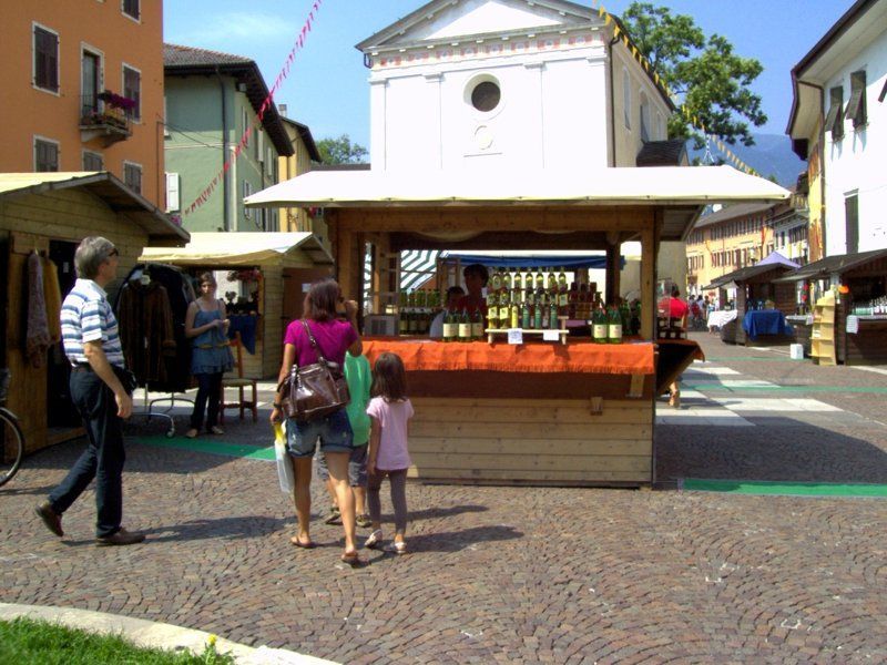 Un gruppo di persone che camminano davanti a un chiosco di legno