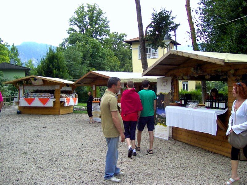 Un gruppo di persone in piedi davanti a una fila di capanne di legno