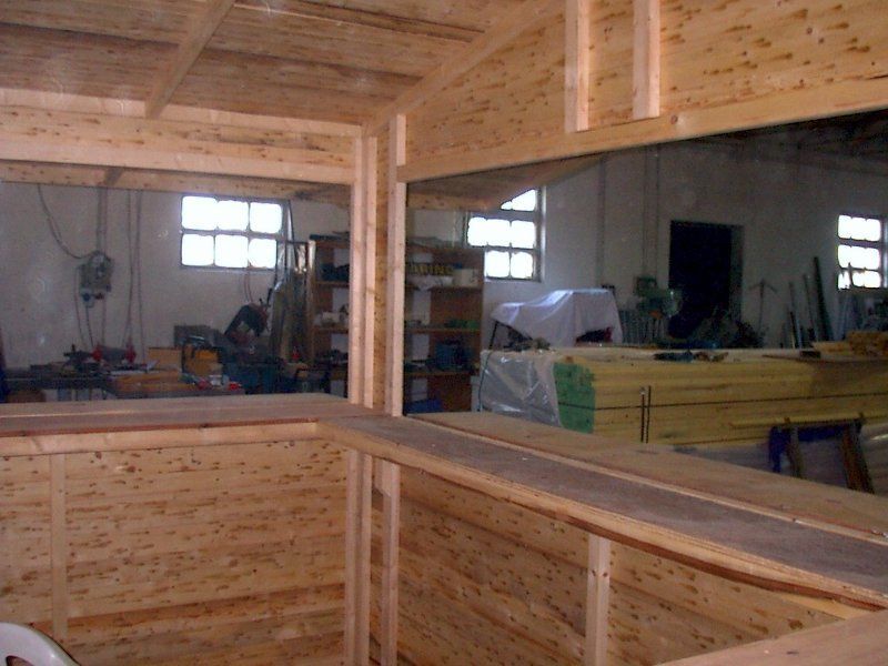 Una stanza di legno con un grande specchio sul muro