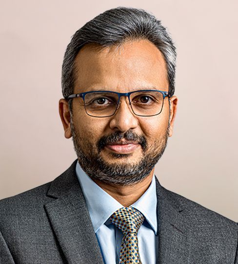 Man with a white beard, glasses, smiles, superimposed on a man in a blue jacket.