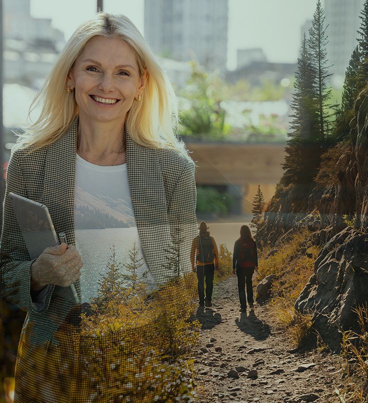 Woman in blazer holding tablet, smiling, with superimposed image of hikers on a trail.