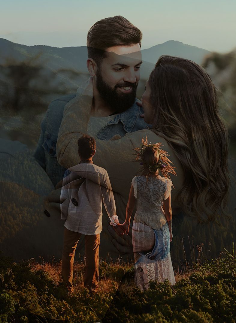Couple holds hands on a mountain. A larger couple, blurred, embraces, with a mountain backdrop.