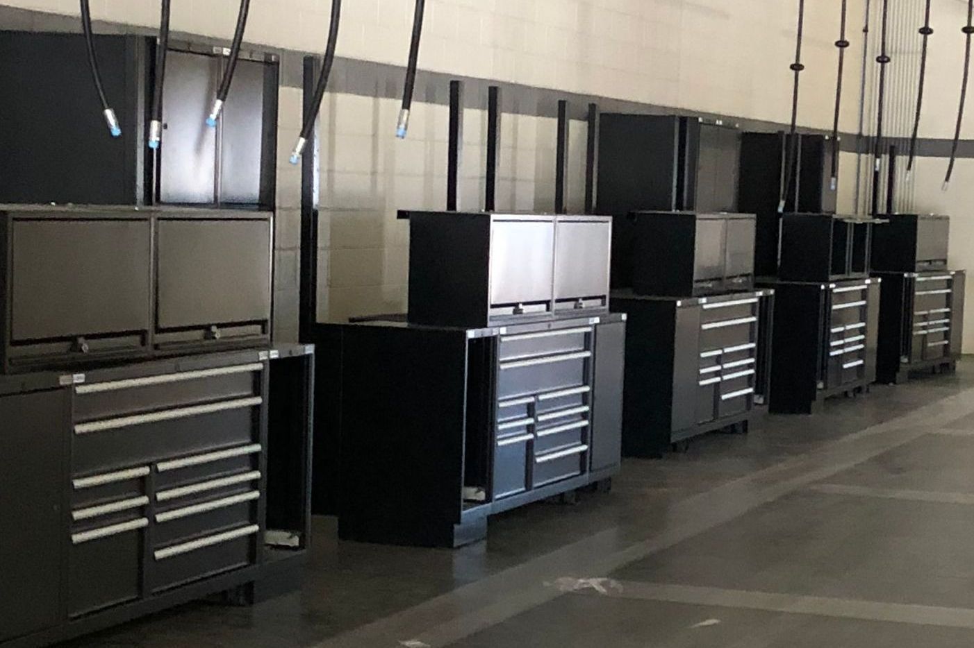 A row of black cabinets and drawers in a garage