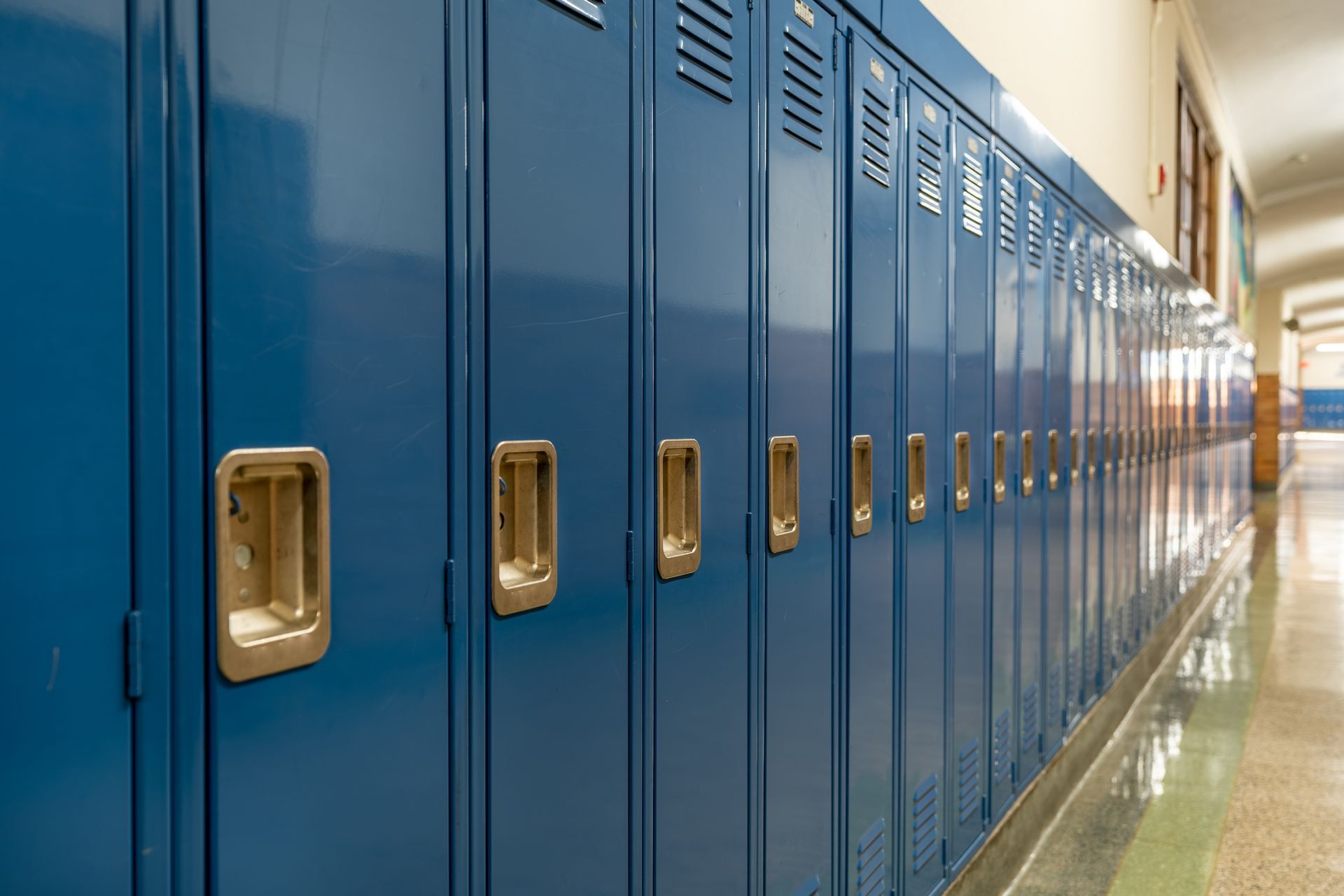 A row of blue lockers in a school hallway.