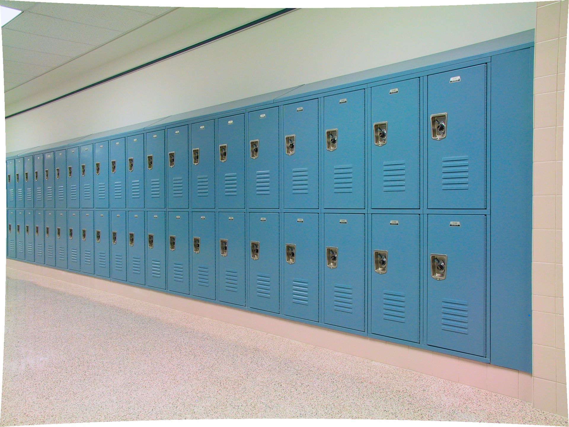 A row of blue lockers in a school hallway