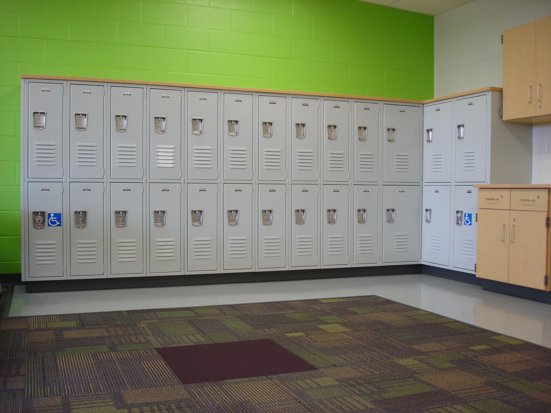 A row of lockers in a room with a green wall