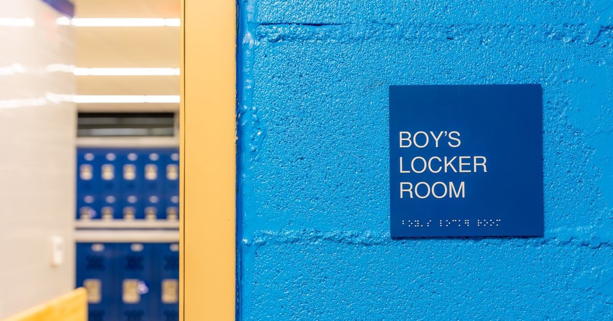 A close-up showing a bright blue wall with a blue sign with 
