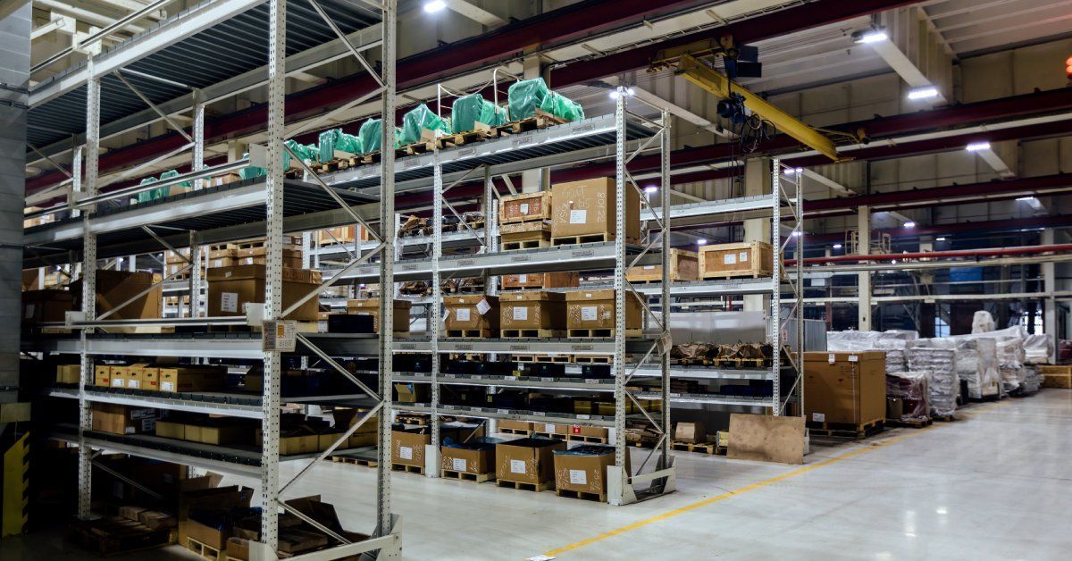 Several shelving units in a warehouse stacked next to each other.