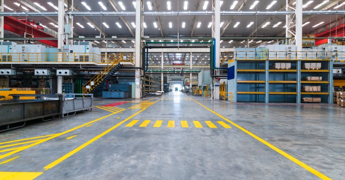 An automotive workshop with the lights on and guide markings on the floor.