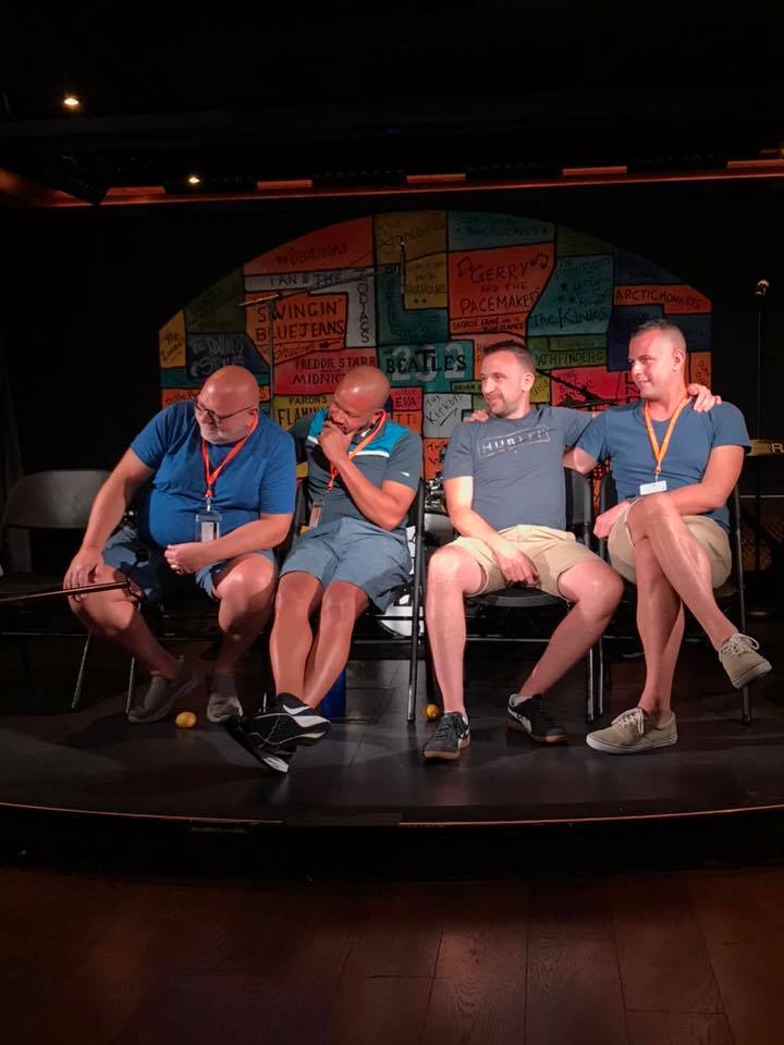 A group of men are sitting in chairs on a stage.