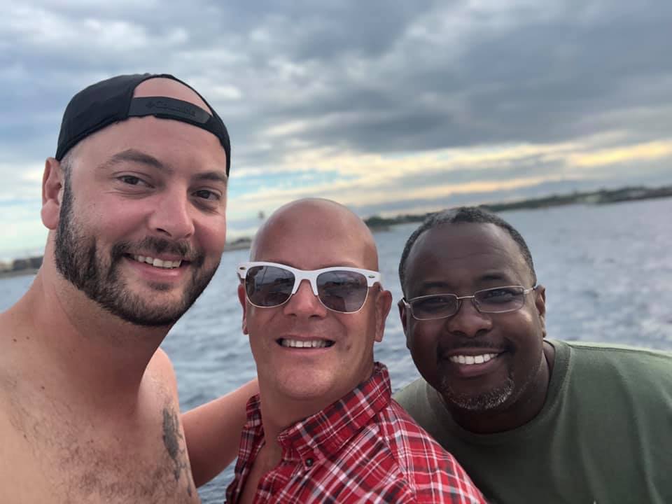 Three men are posing for a picture on a boat.