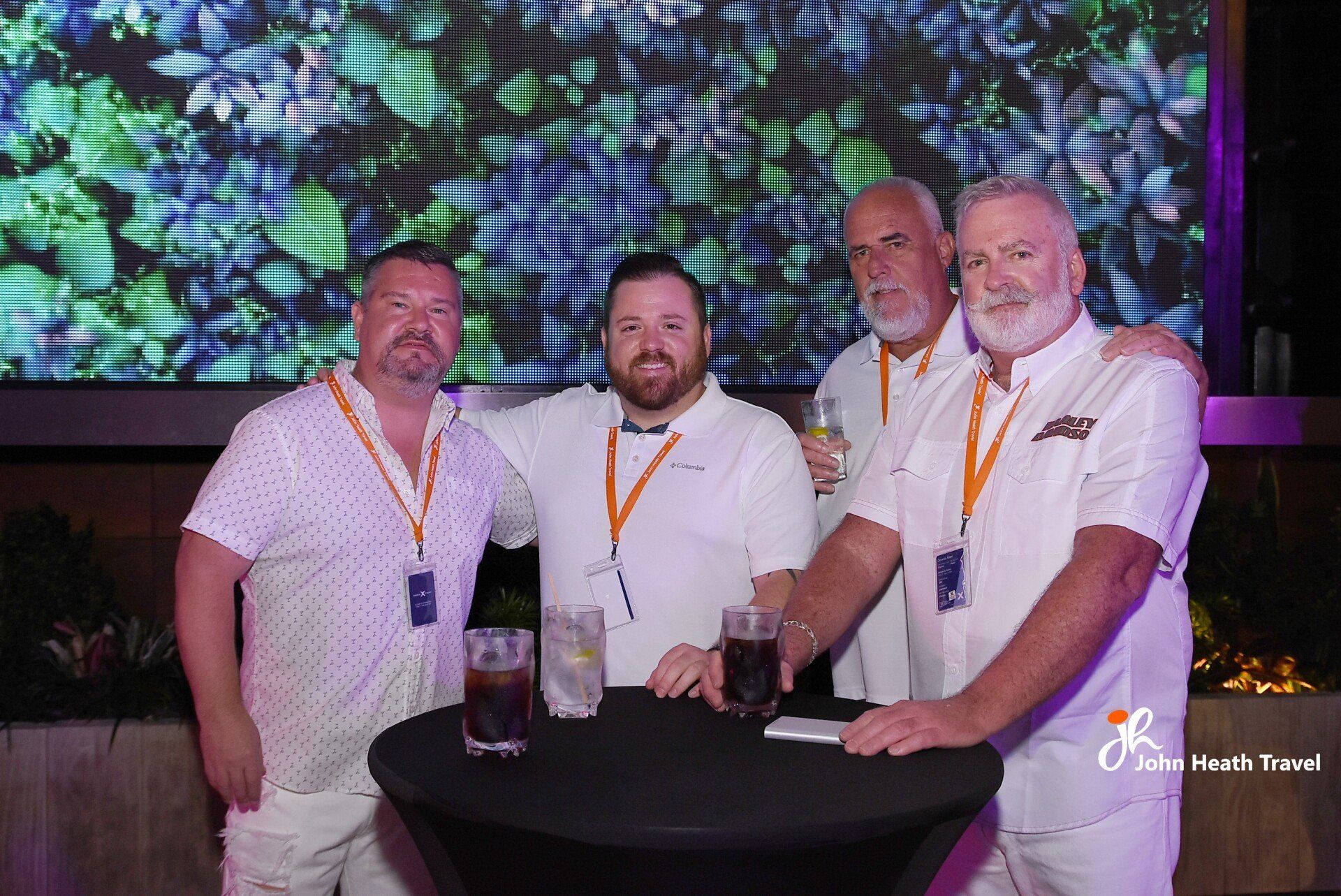 A group of men are posing for a picture while standing around a table.