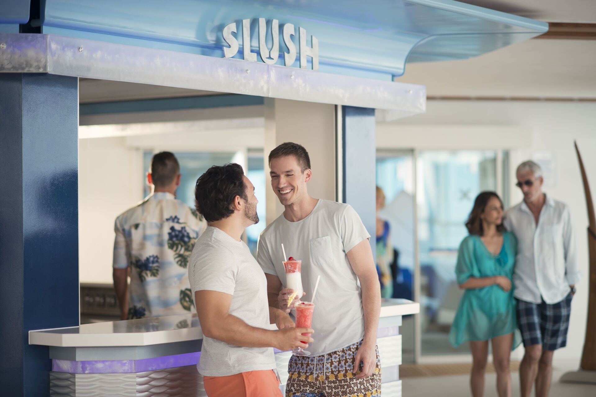 Two men are standing next to each other in front of a slush bar.
