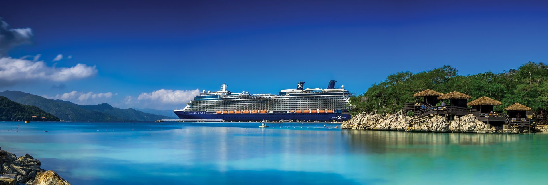 A cruise ship is docked in the middle of a large body of water.