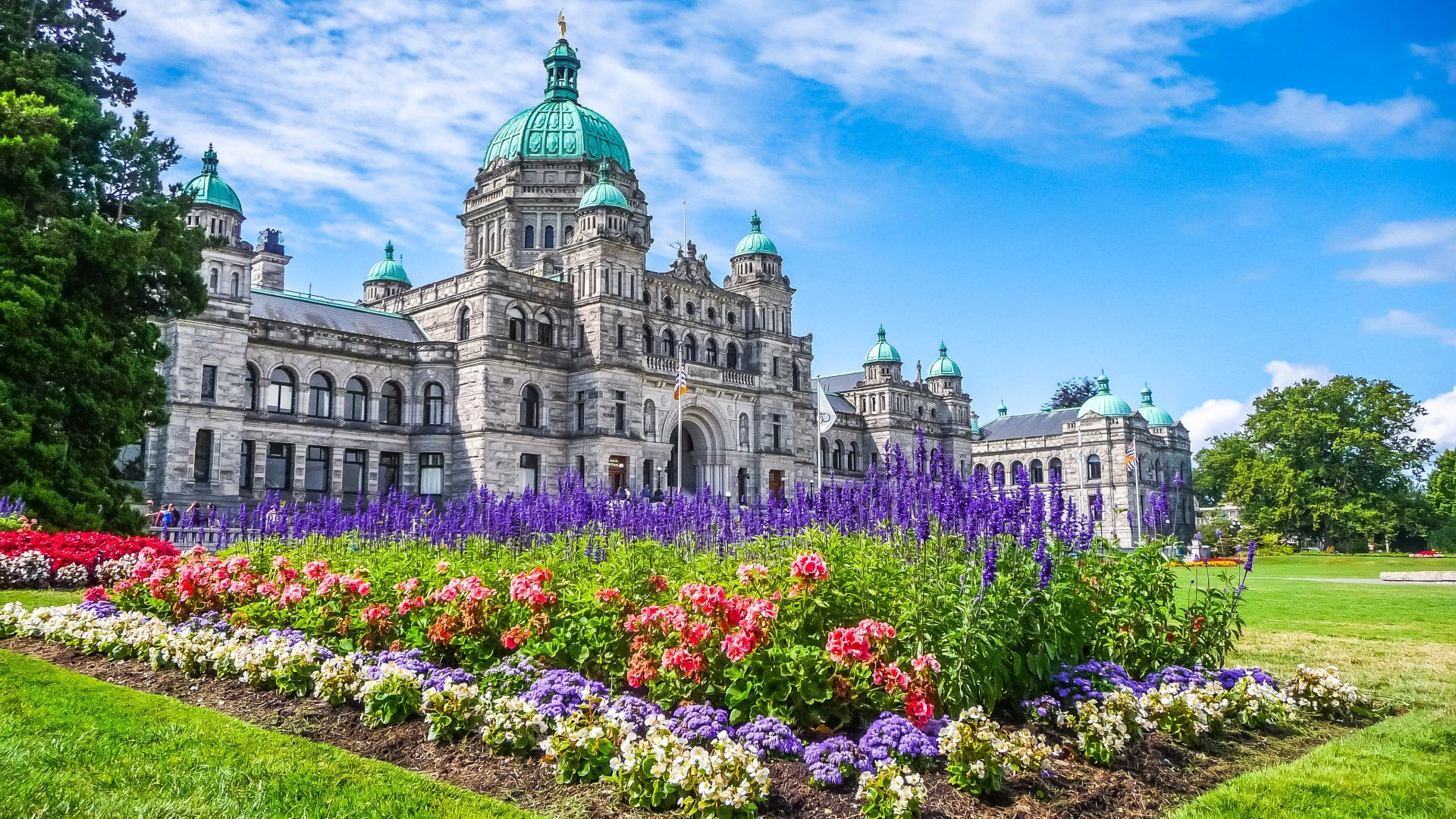 A large building with a dome and flowers in front of it.