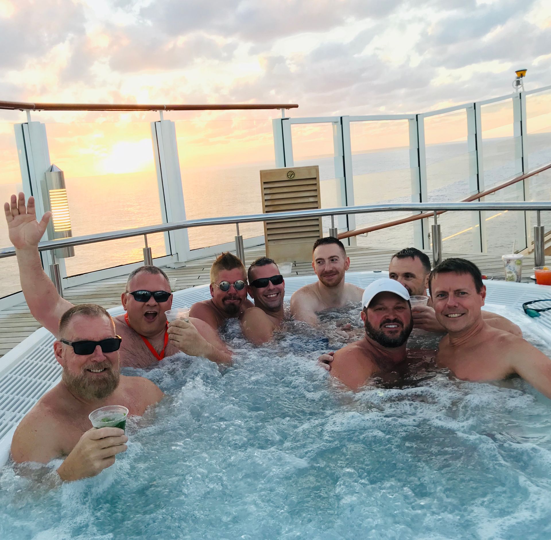 A group of men are posing for a picture in a hot tub