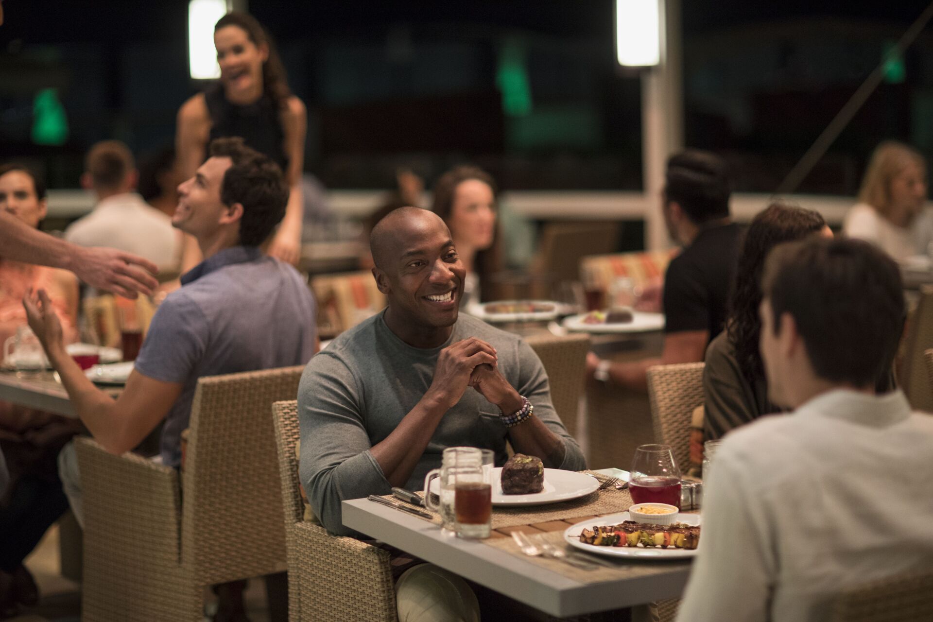 A group of people are sitting at tables in a restaurant.