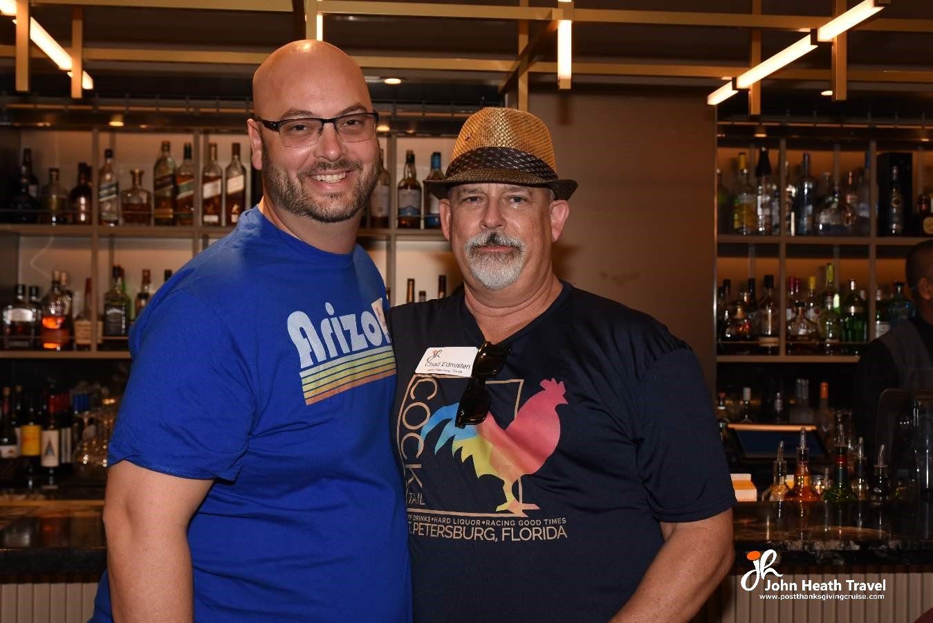 Two men are posing for a picture in front of a bar.