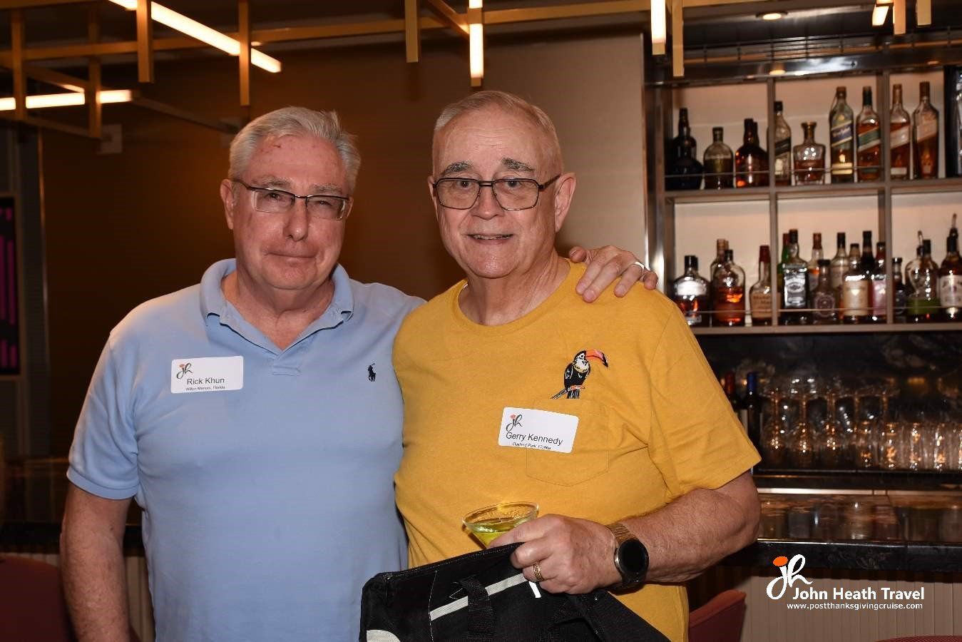 Two men are posing for a picture in front of a bar.