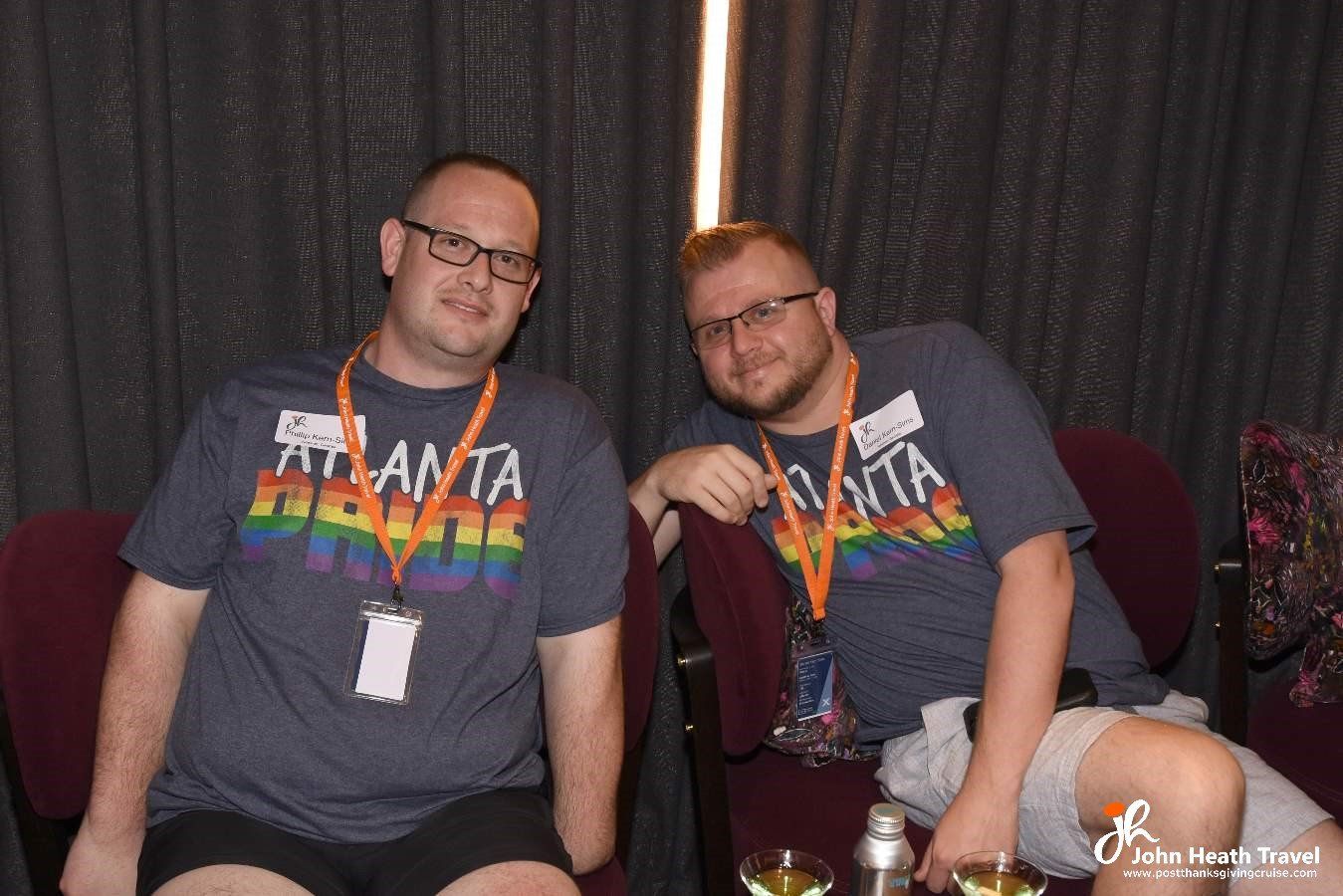 Two men are sitting next to each other on a couch.