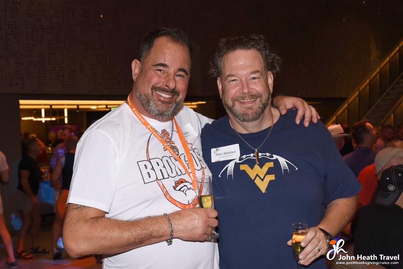 Two men are posing for a picture and one of them has a w on his shirt.