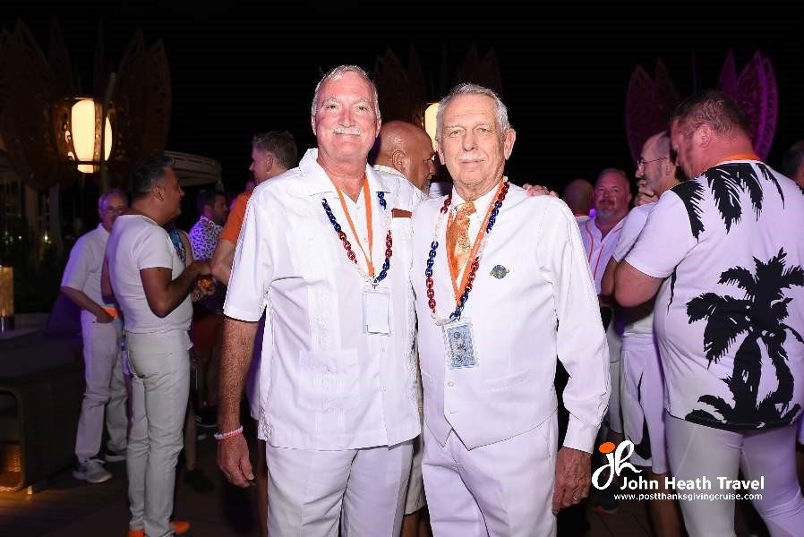 Two men in white shirts are posing for a picture.