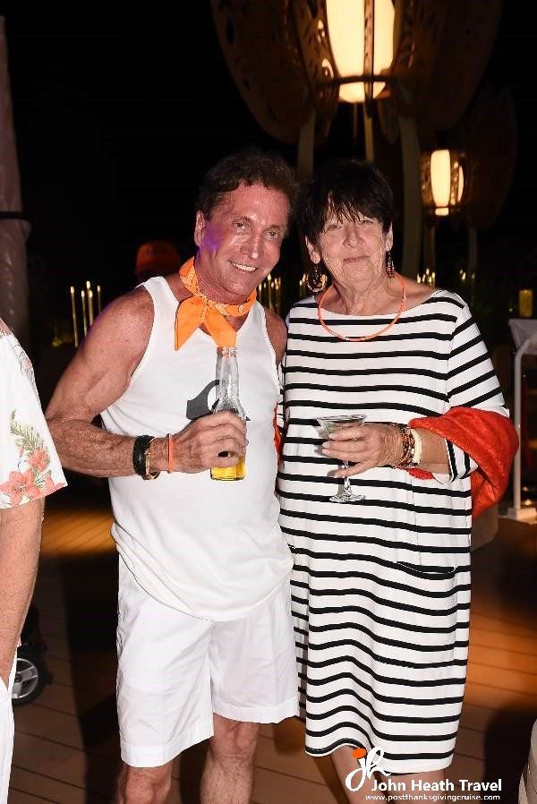 A man and a woman are posing for a picture while holding drinks.