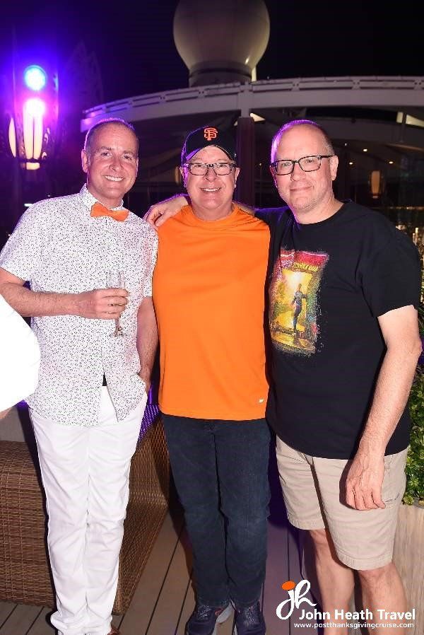 Three men are posing for a picture together at a party.