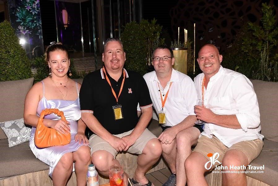 A group of people are posing for a picture while sitting on a couch.