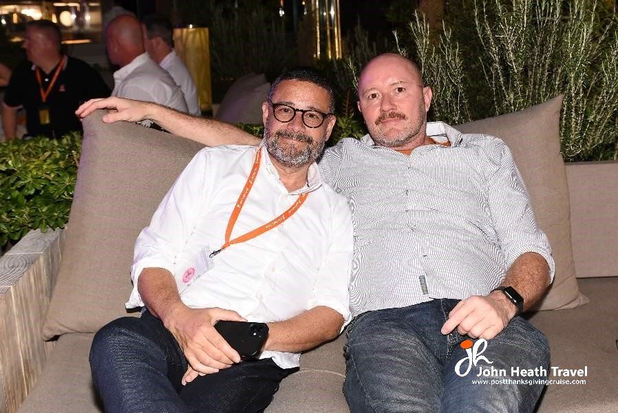 Two men are sitting next to each other on a couch.