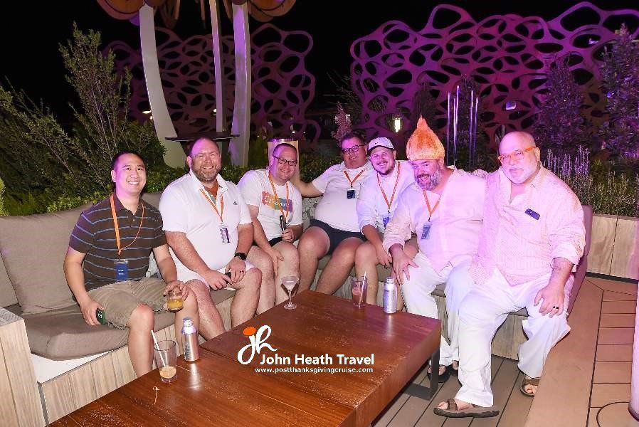 A group of men are posing for a picture while sitting around a table.