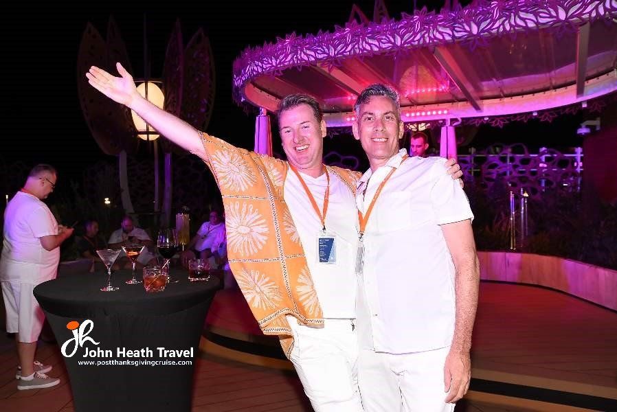 Two men are posing for a picture in front of a gazebo.