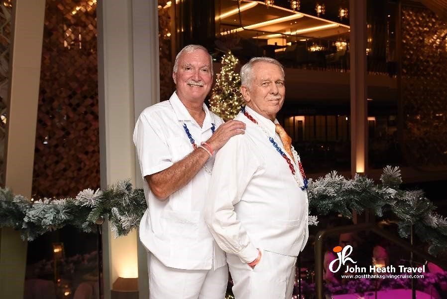 Two men in white shirts and ties are posing for a picture.