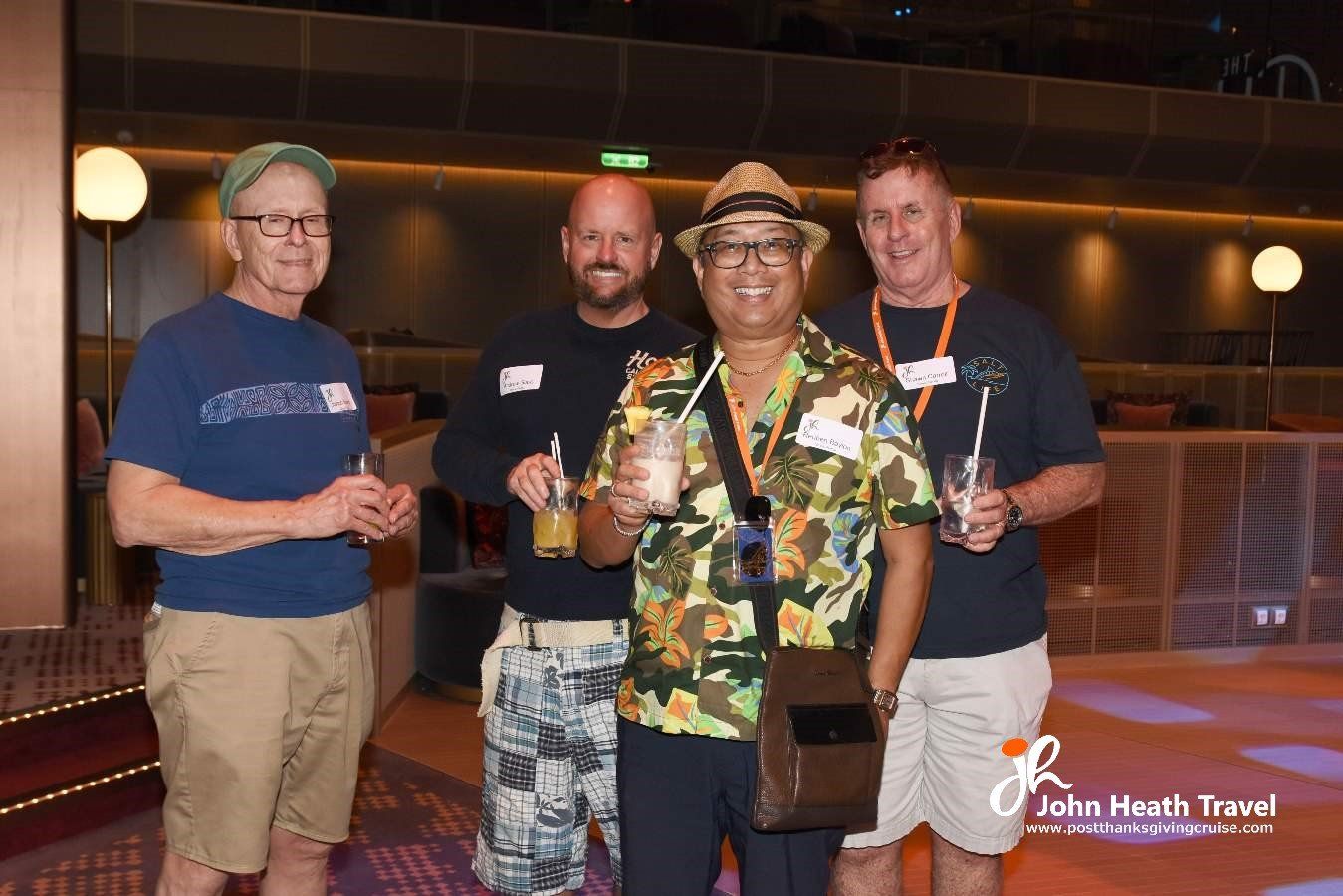 A group of men are posing for a picture while holding drinks.