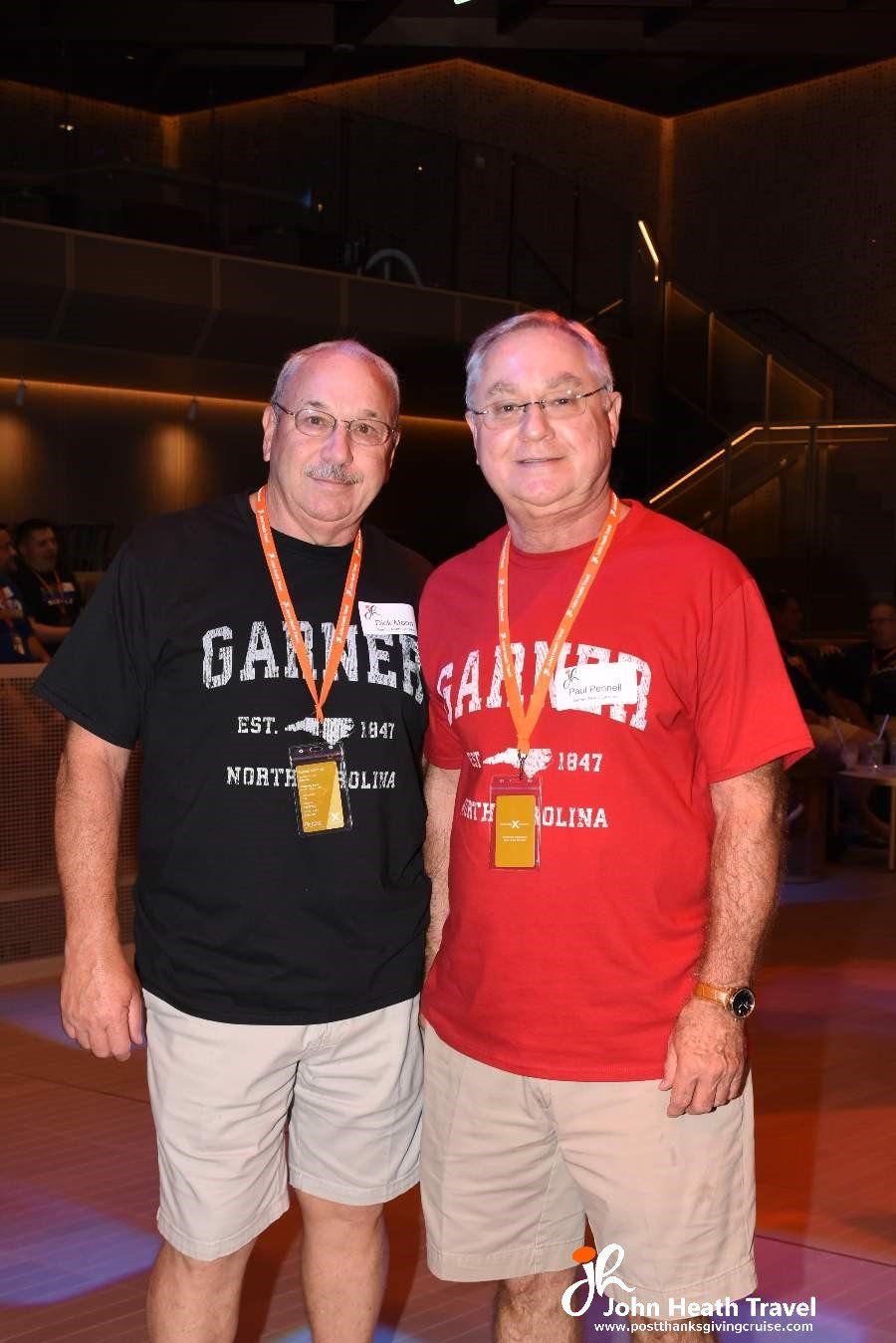 Two men standing next to each other wearing garnet shirts
