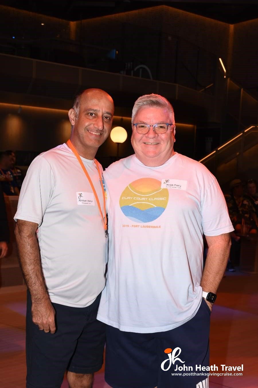 Two men are posing for a picture together in front of a building.