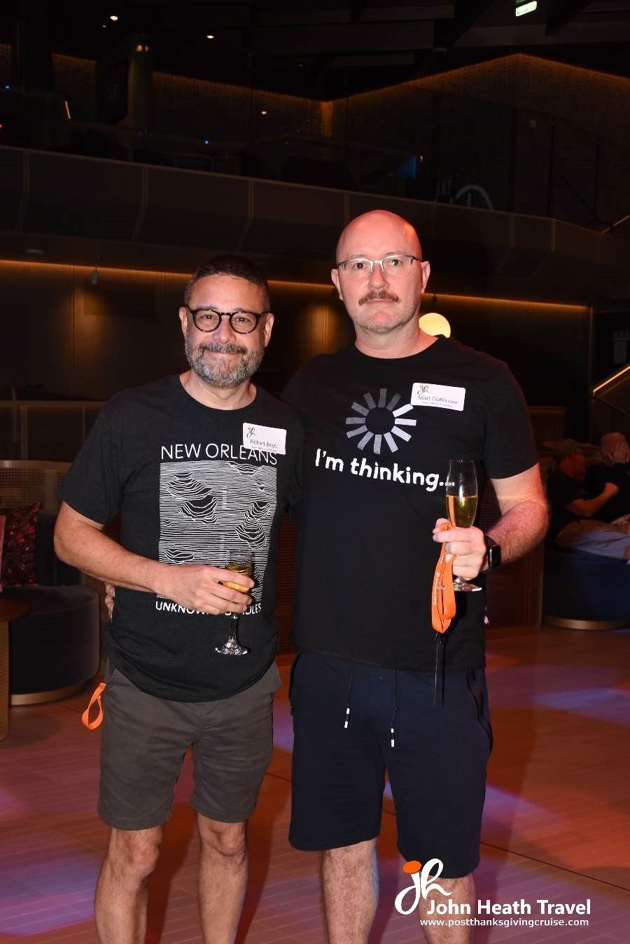 Two men are standing next to each other holding champagne glasses.