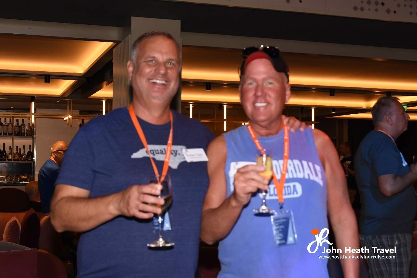 Two men standing next to each other holding wine glasses