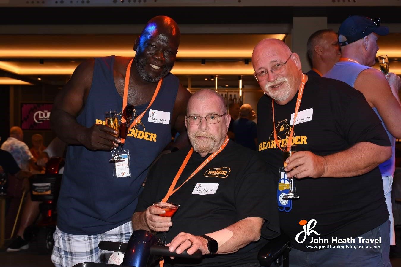 Three men are posing for a picture with one of them in a wheelchair.